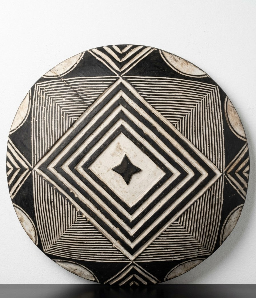 Bamileke tribal shield tribal shield (or Cameroon battle shield), commonly used today as African tribal wall art. A perfectly circular, slightly convex platter hand-sculpted from a single piece of dense hardwood.